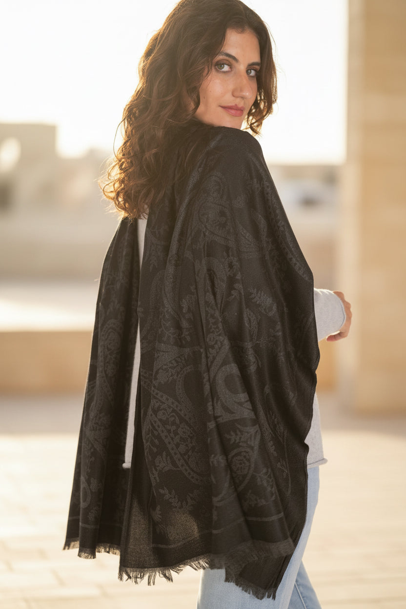 Woman wearing a black patterned scarf on a white background