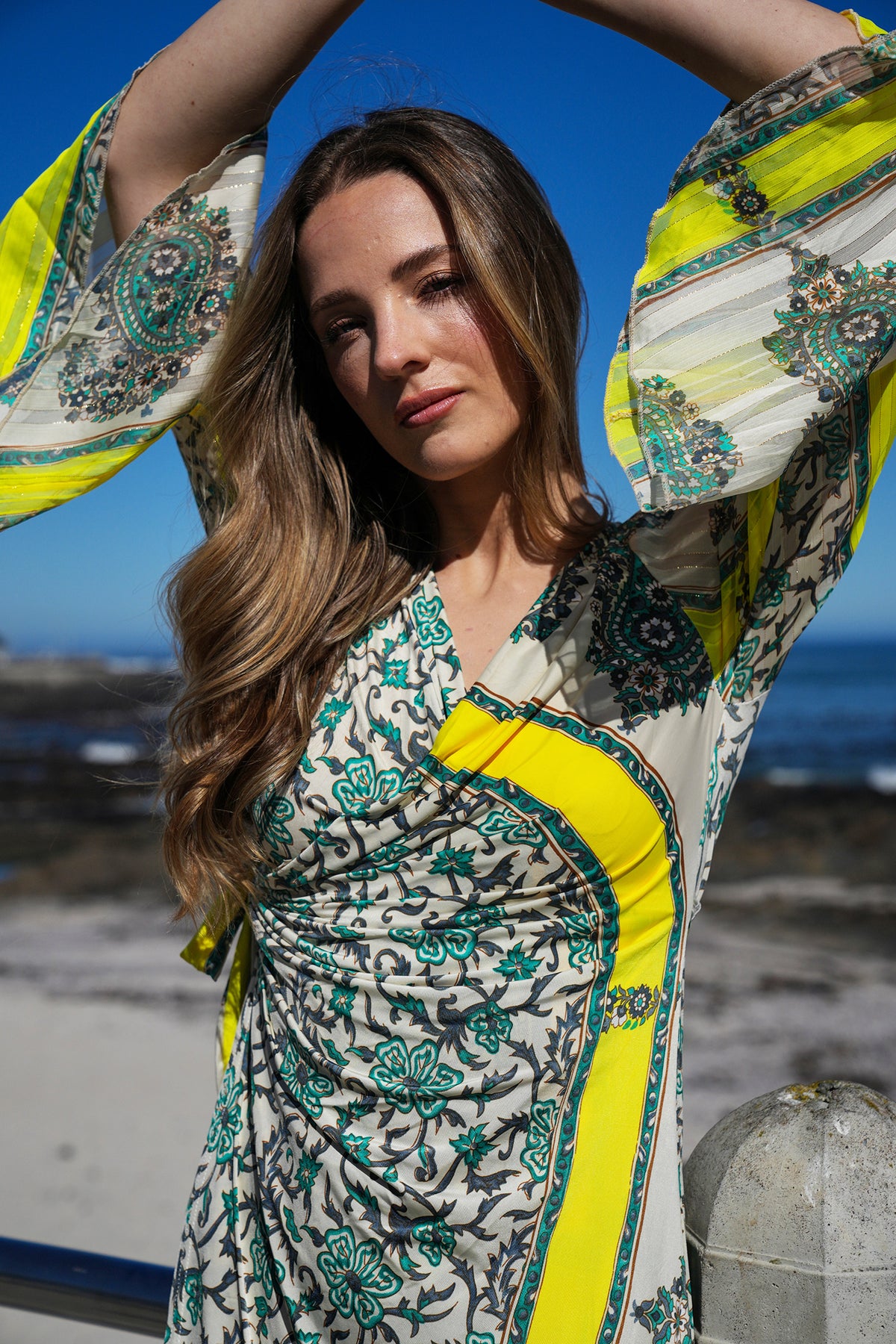 Woman wearing a colorful patterned dress with a blue sky background