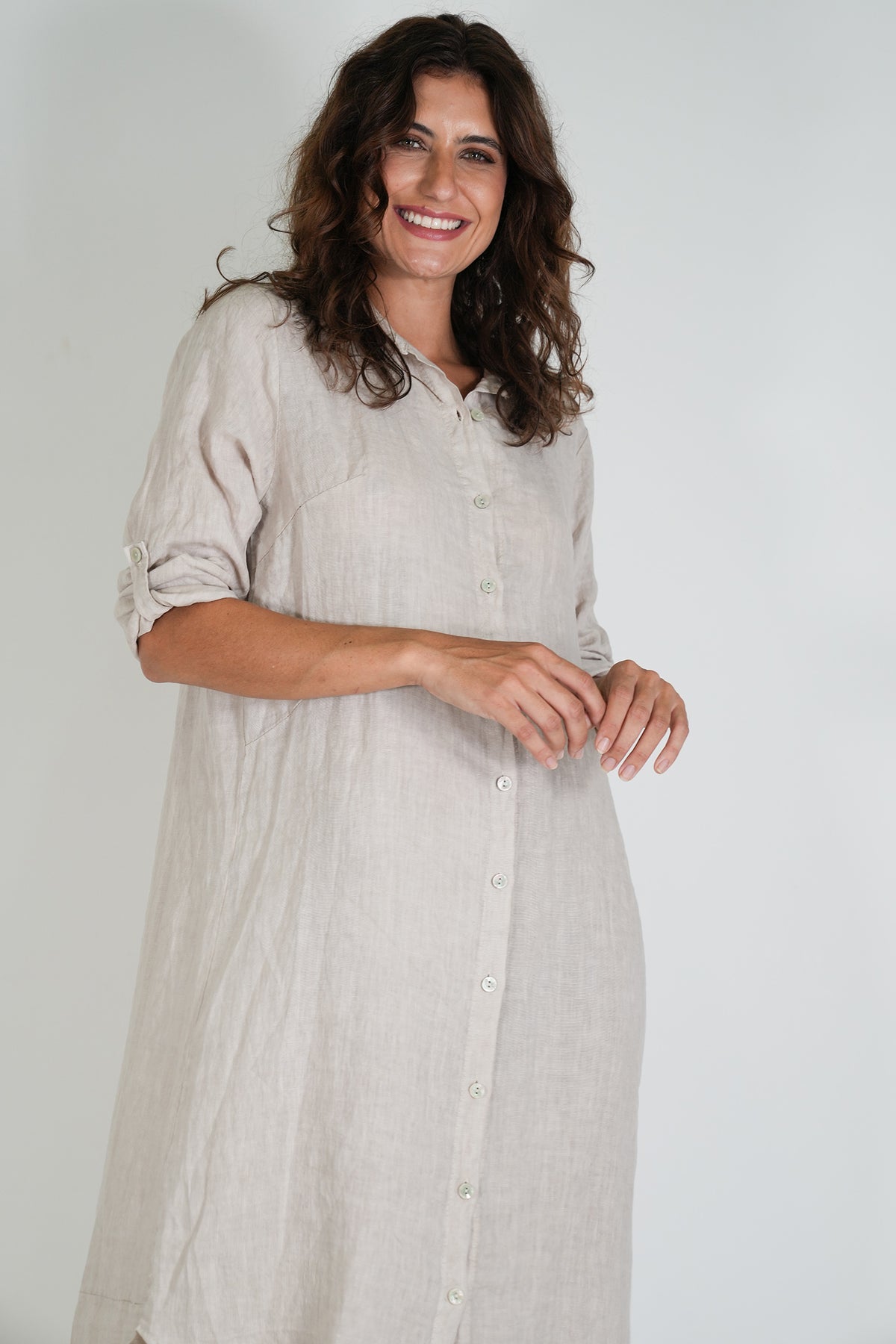 Woman wearing a light gray dress against a white background