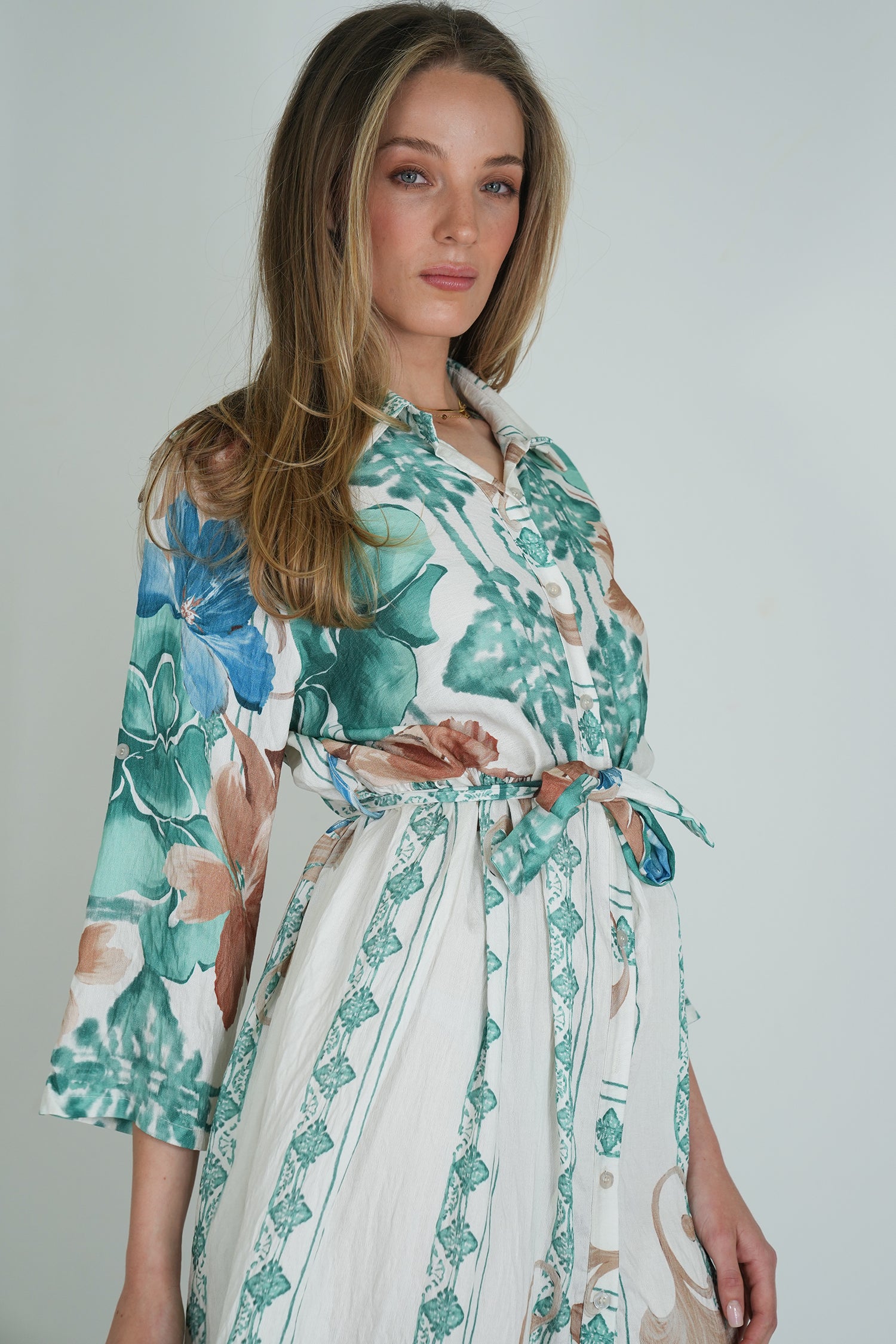Woman wearing a floral patterned robe against a plain background