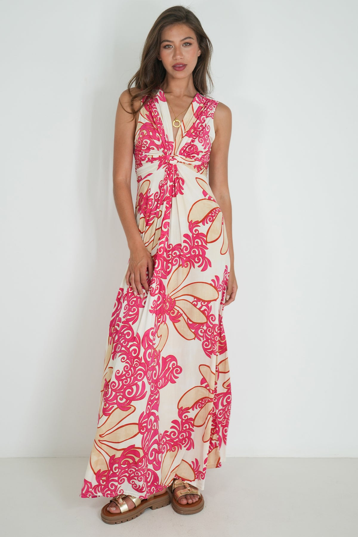 Woman wearing a floral dress with pink and beige patterns on a white background