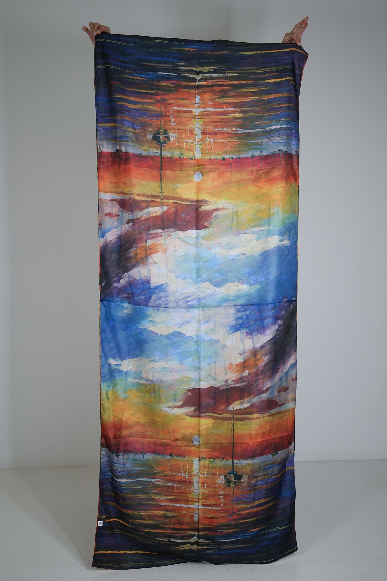 Colourful fabric withan abstract design held up against a plain background