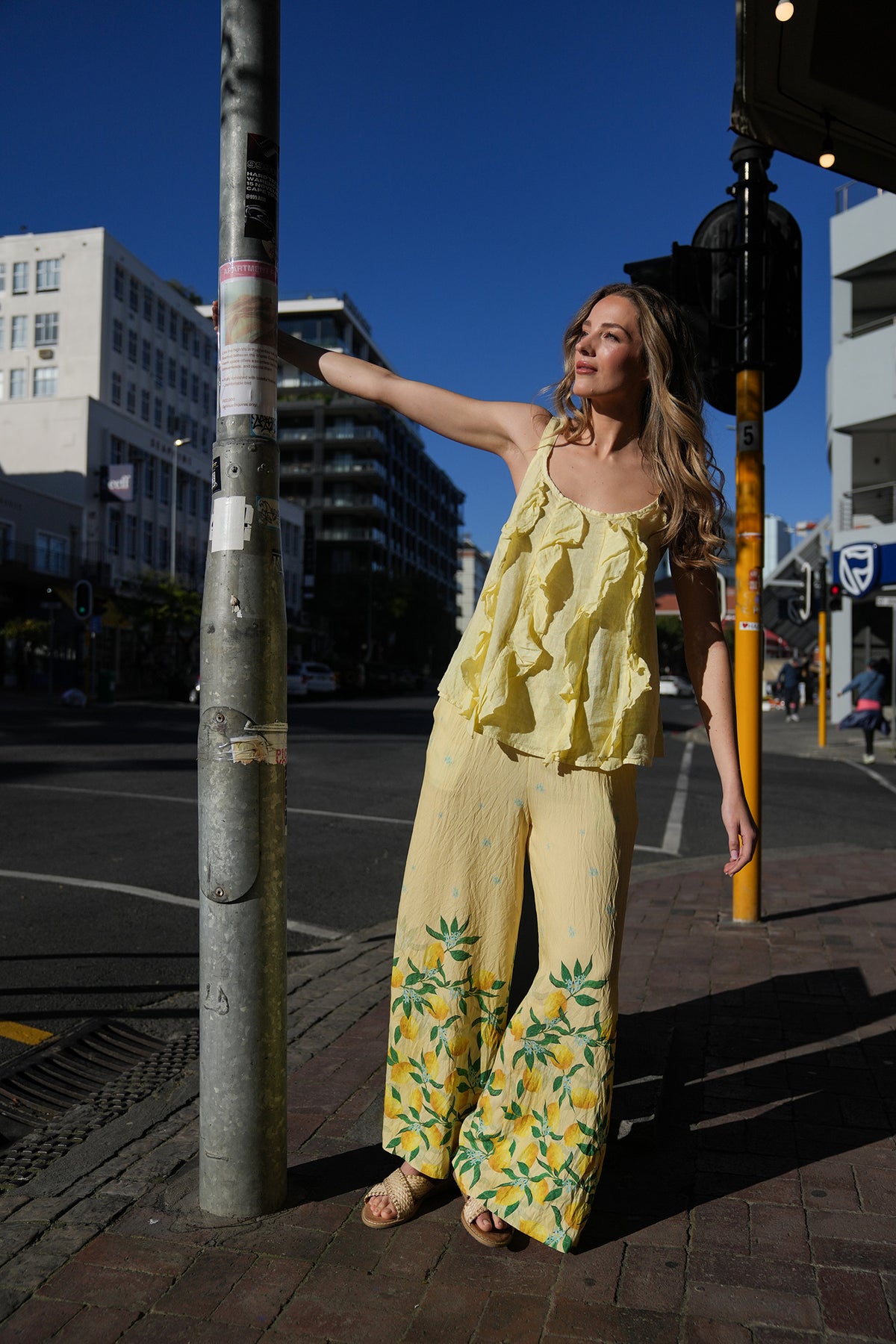 Woman in a yellow outfit standing on a city street