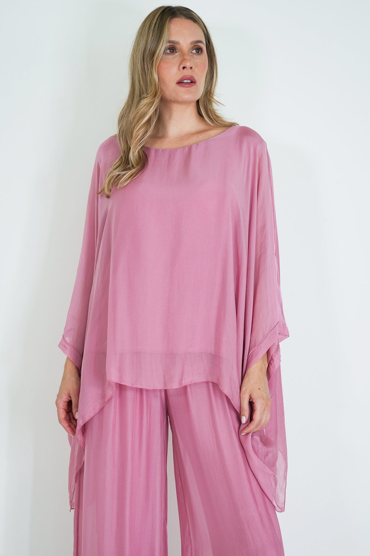 Woman wearing a pink outfit with a plain white background