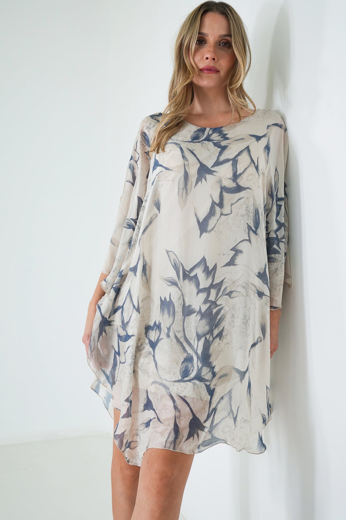 Woman wearing a patterned dress against a white background