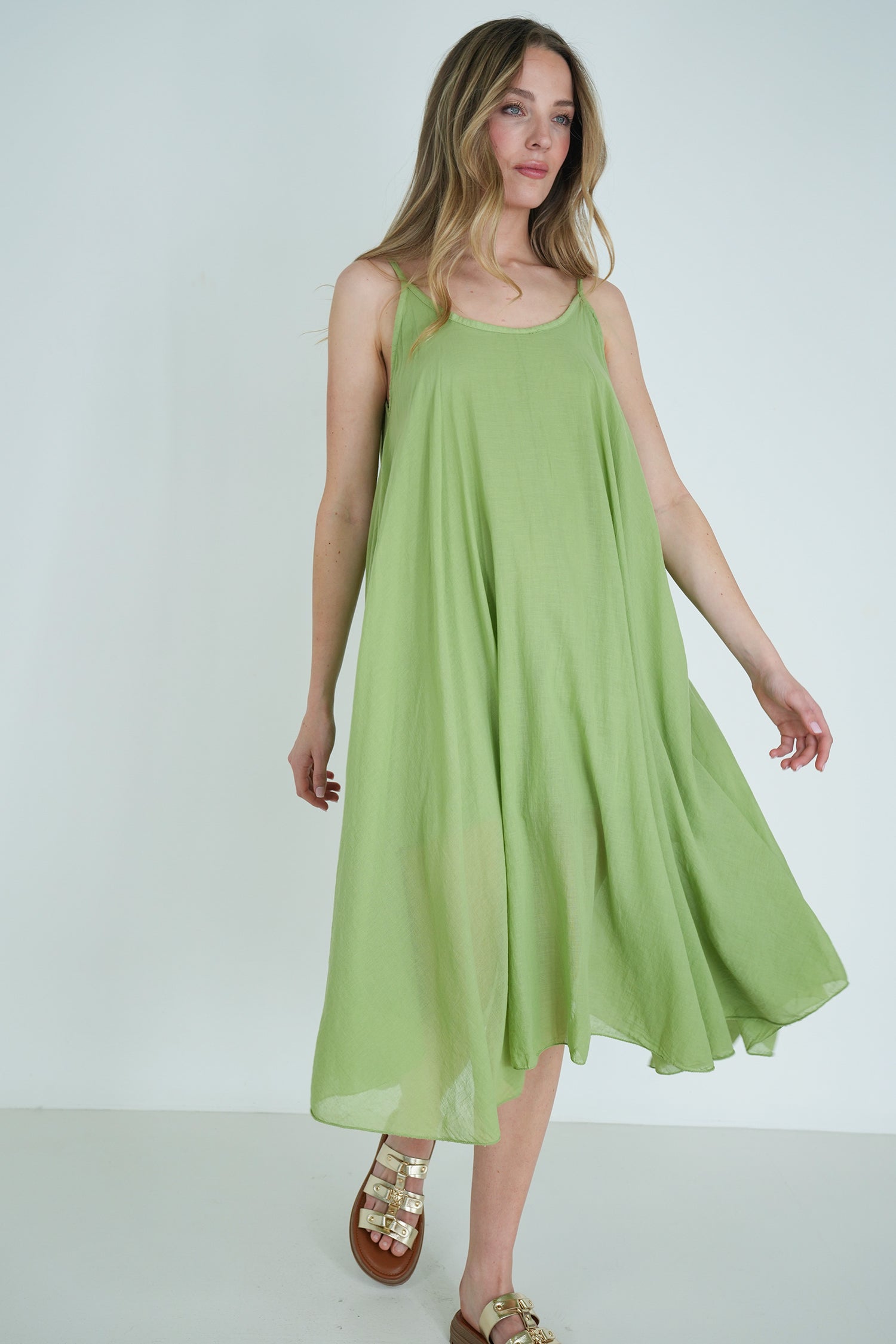 Woman wearing a light green dress against a white background