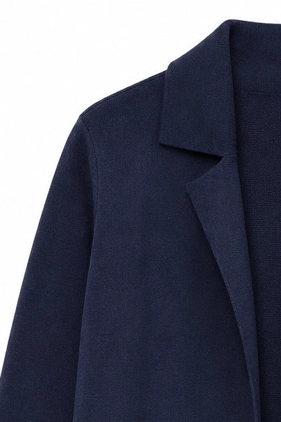 Close-up of a dark navy blue textured blazer or coat showing the collar and lapel detail against a plain white background.