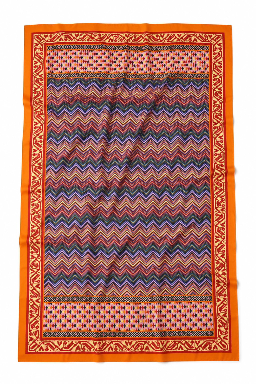 A rectangular patterned scarf laid flat on a white background, featuring a vibrant orange border and a central chevron pattern in shades of red, blue, purple, and black.