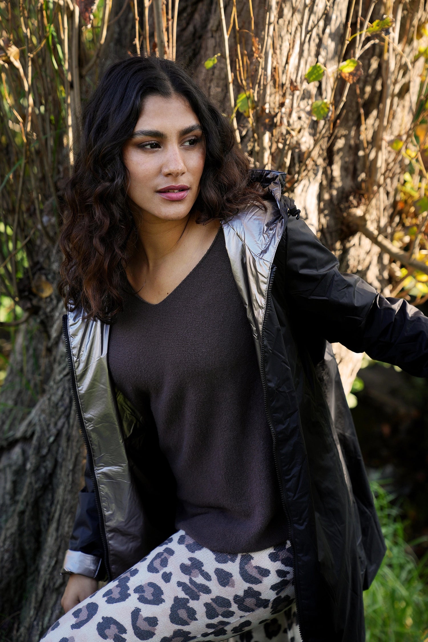 Woman standing outdoors with trees and grass in the background