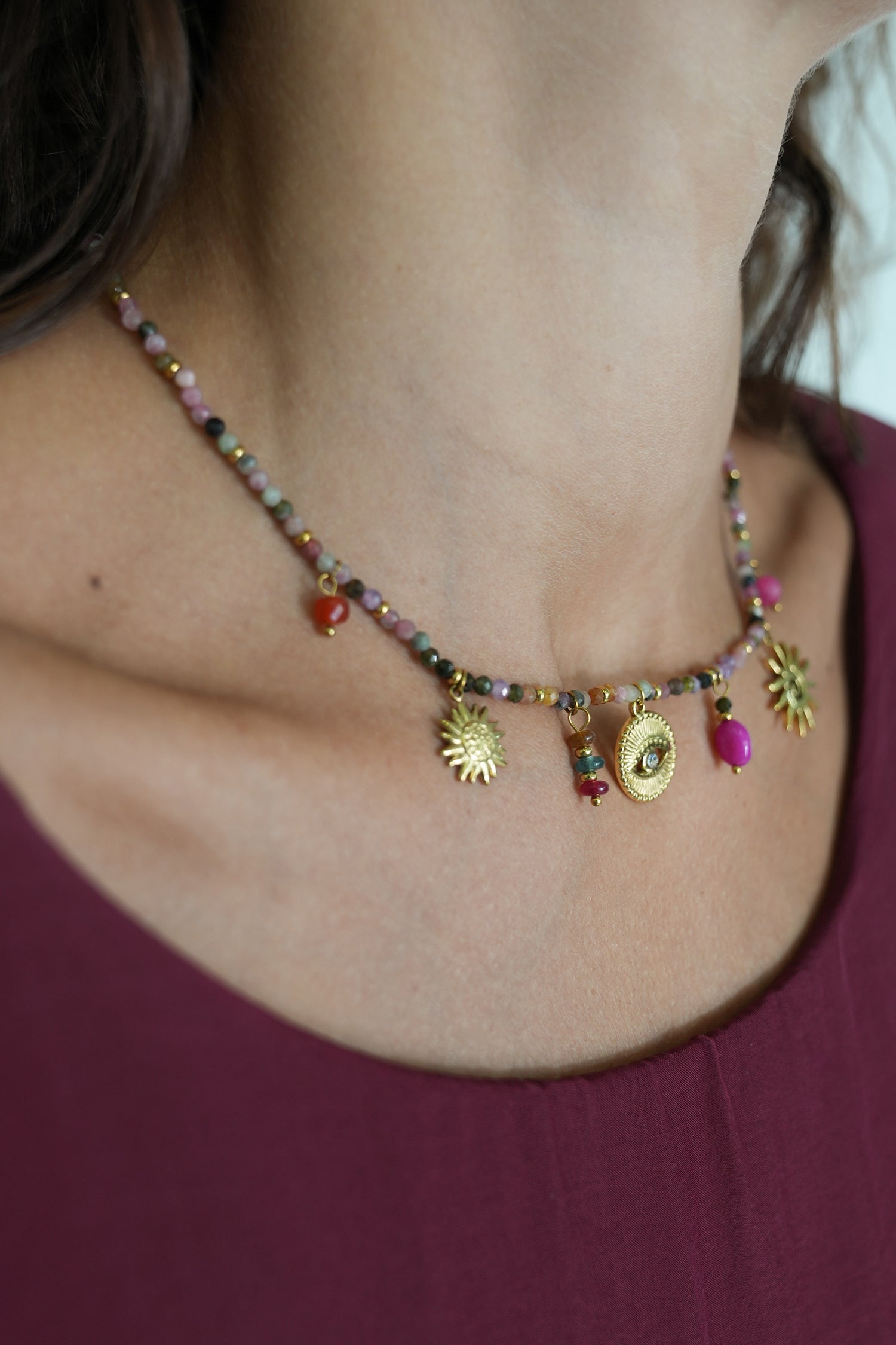 Necklace with colorful beads and charms worn by a person