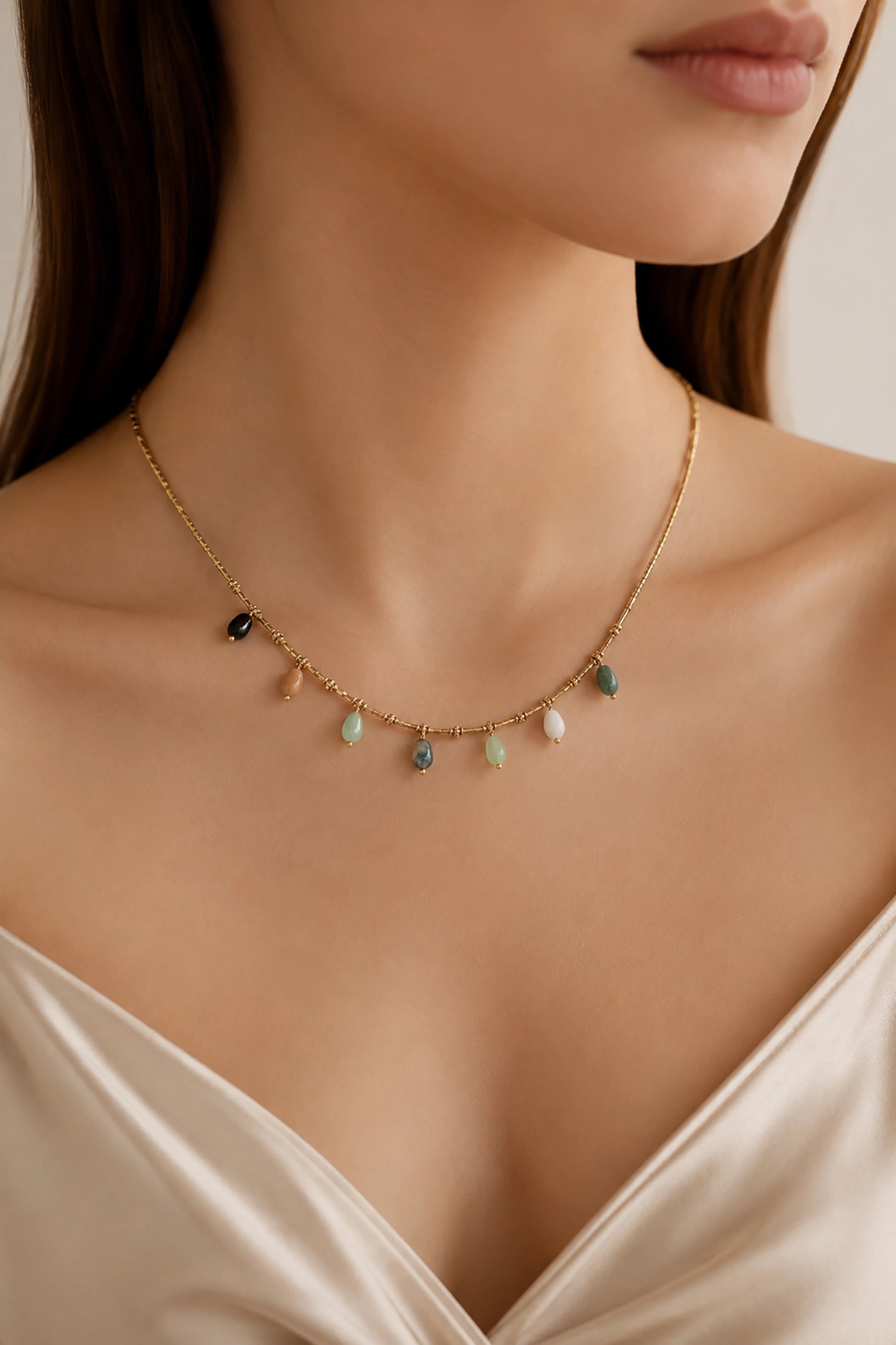 Necklace with small beads worn by a model against a neutral background