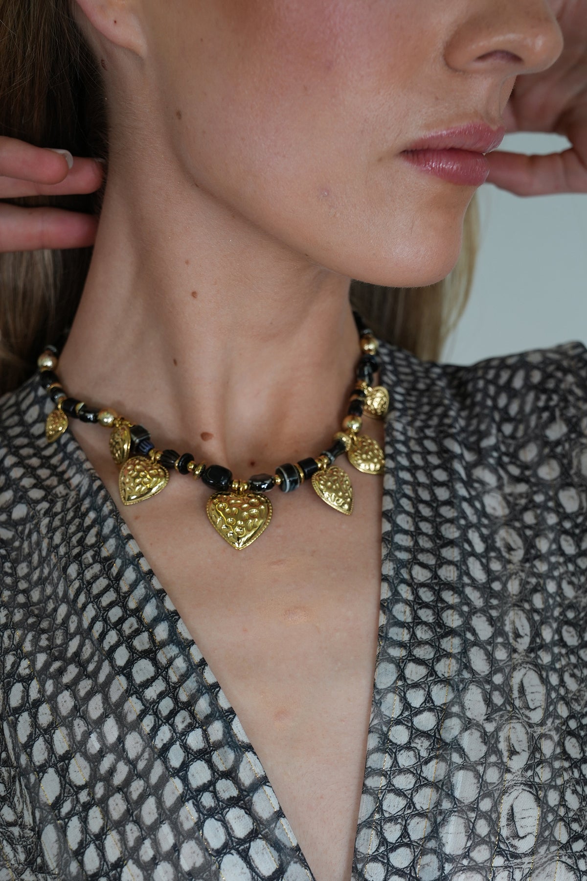 Necklace with heart-shaped pendants worn by a person