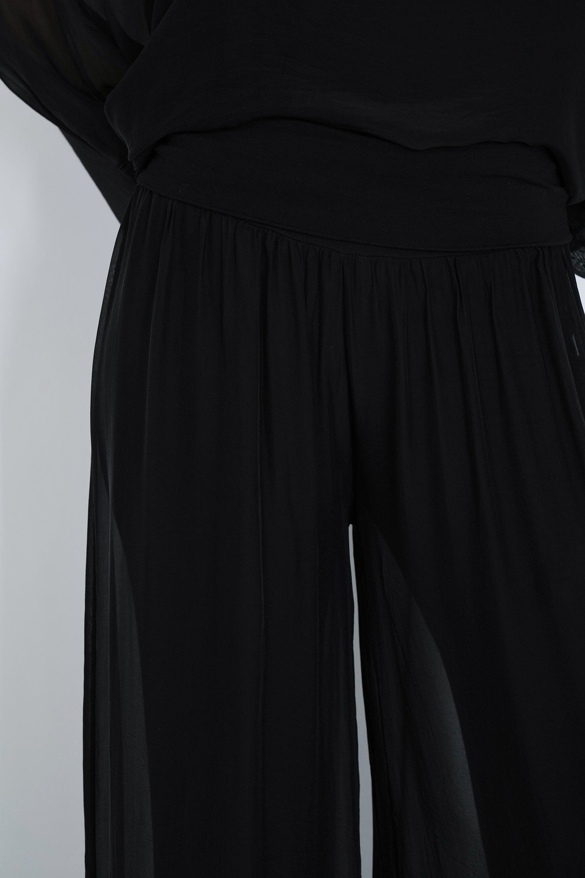 Black dress with a belt on a light gray background