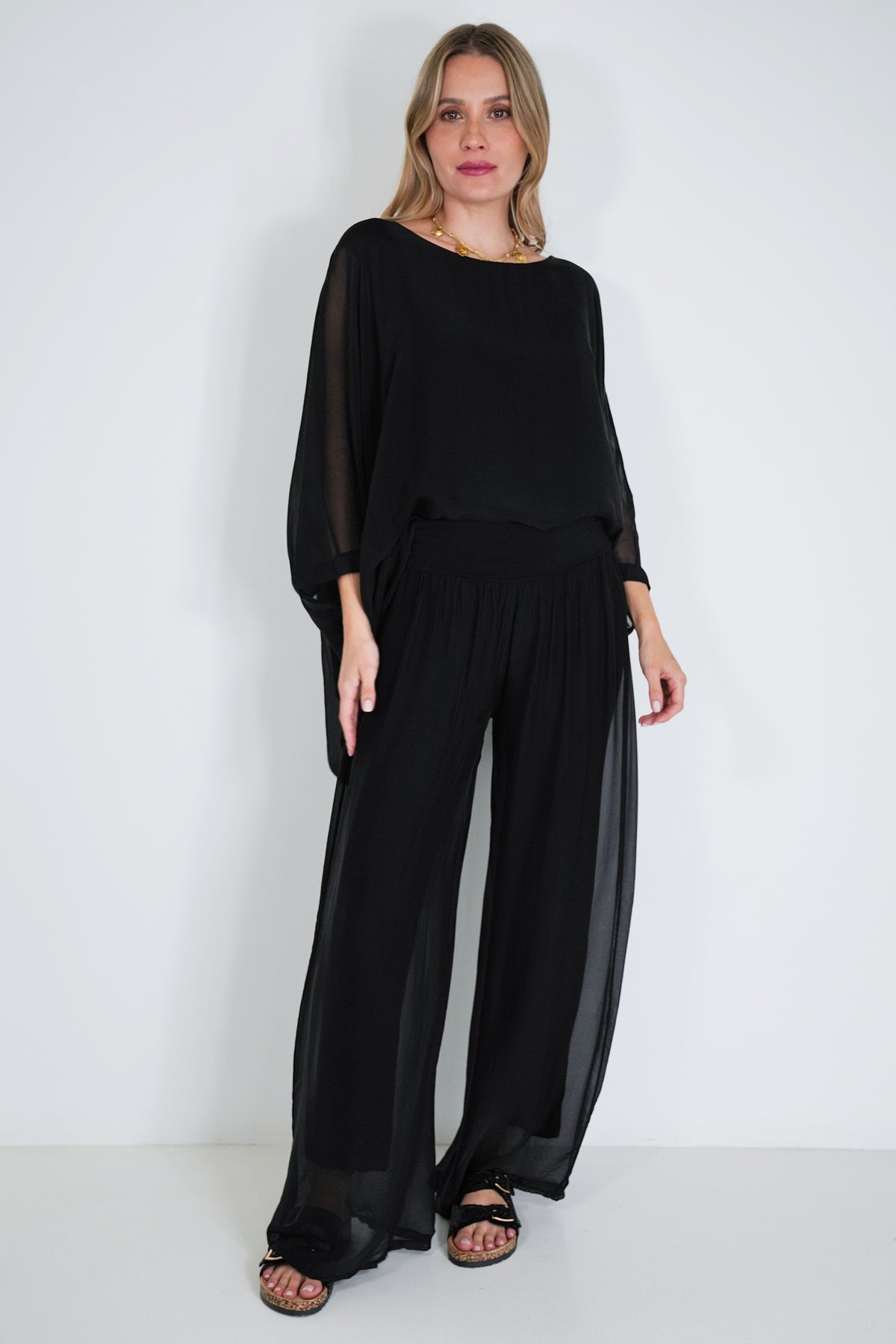Woman wearing a black outfit against a white background