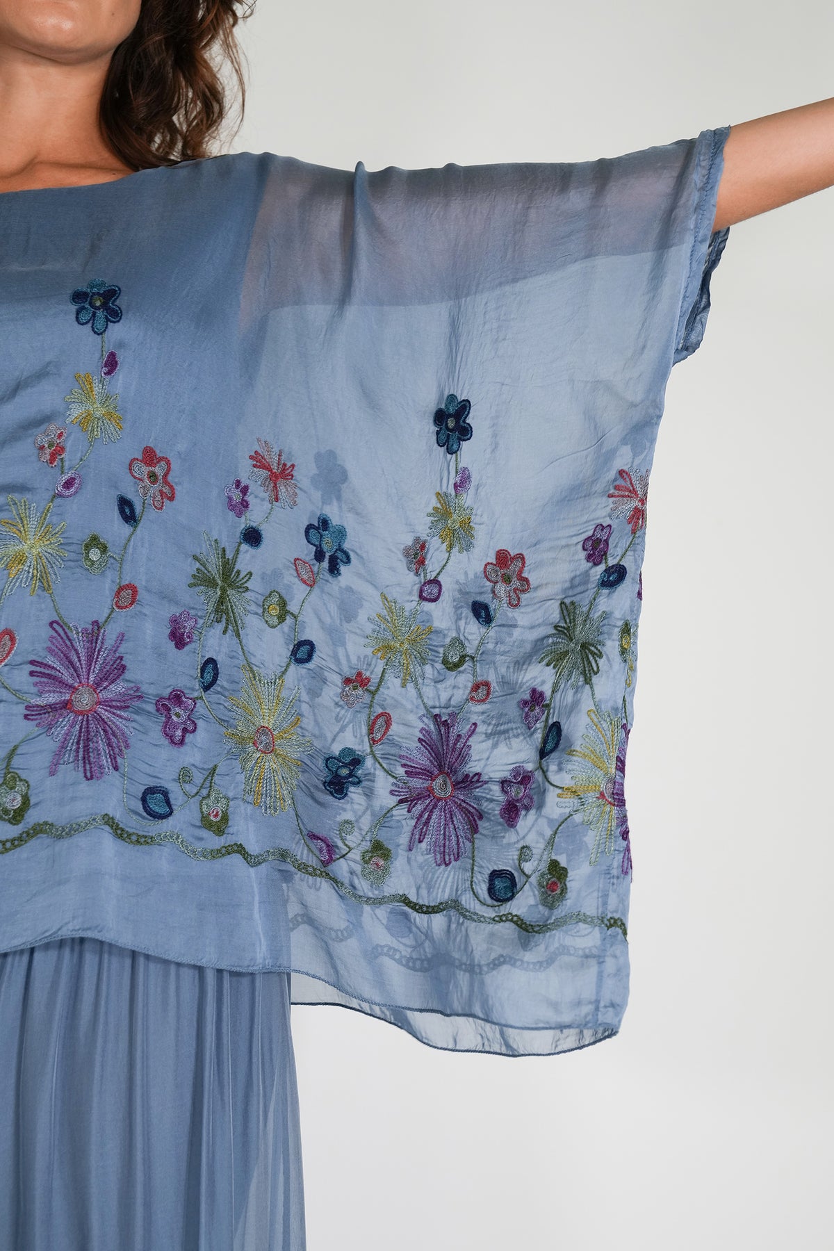 Light blue embroidered dress with floral patterns on a plain background