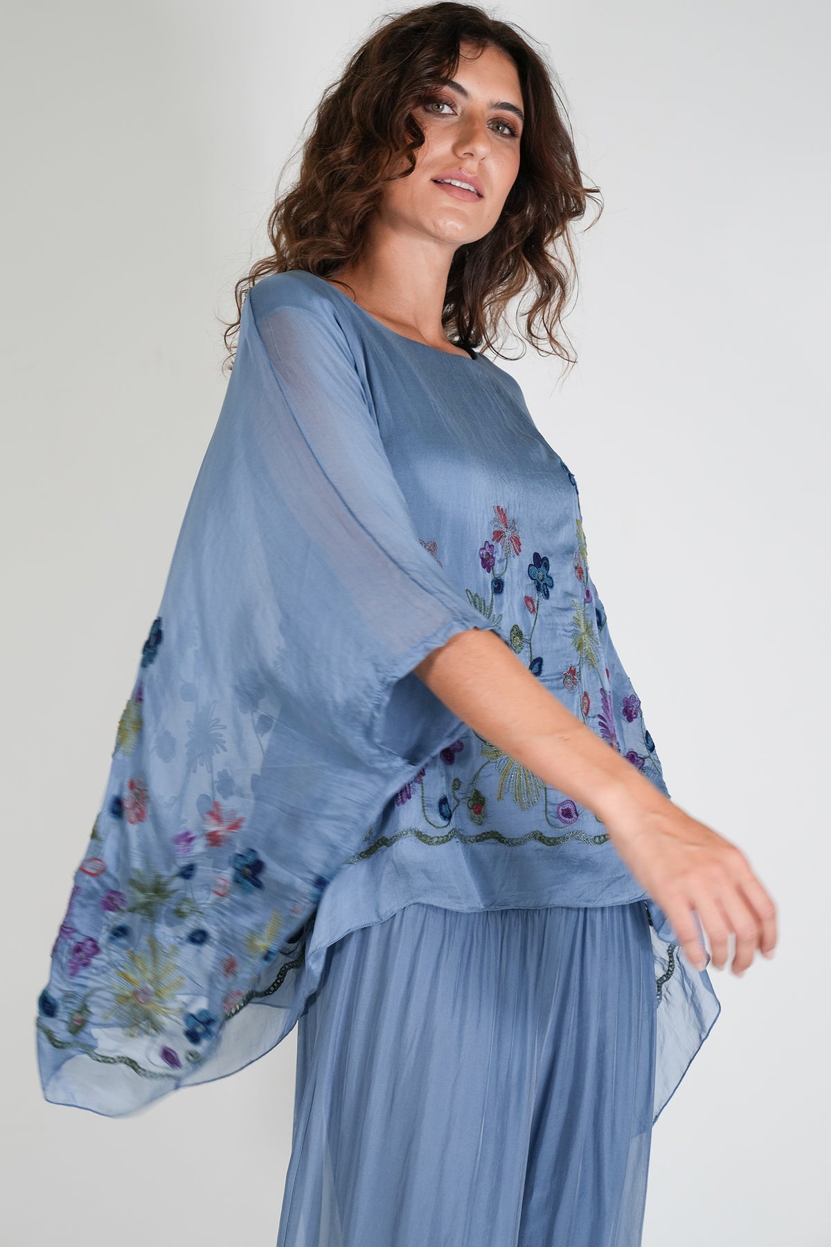 Woman wearing a blue floral dress against a white background