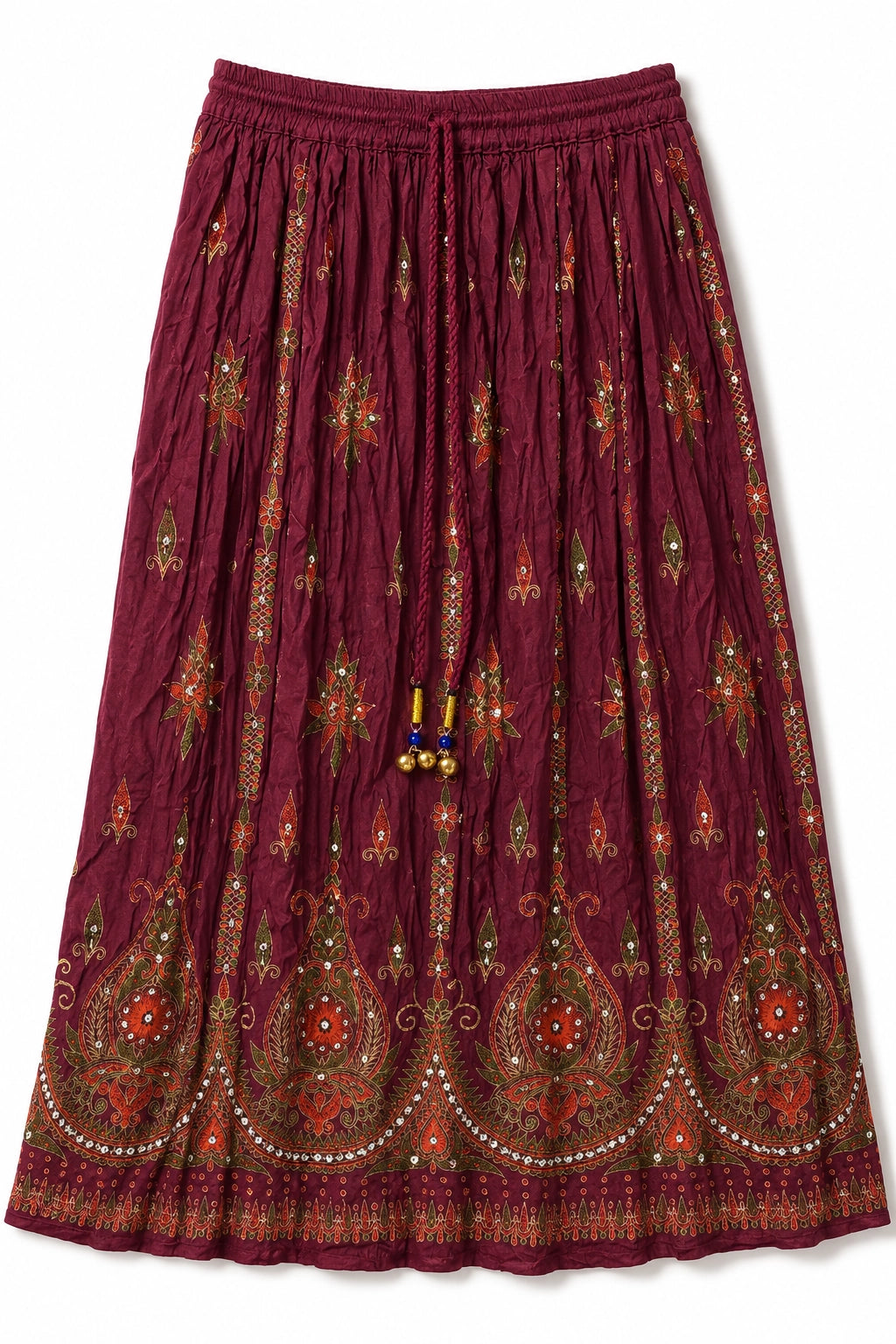 A pleated bohemian-style midi skirt in deep burgundy, decorated with intricate red, green, and gold paisley and floral embroidery and bead tassels.