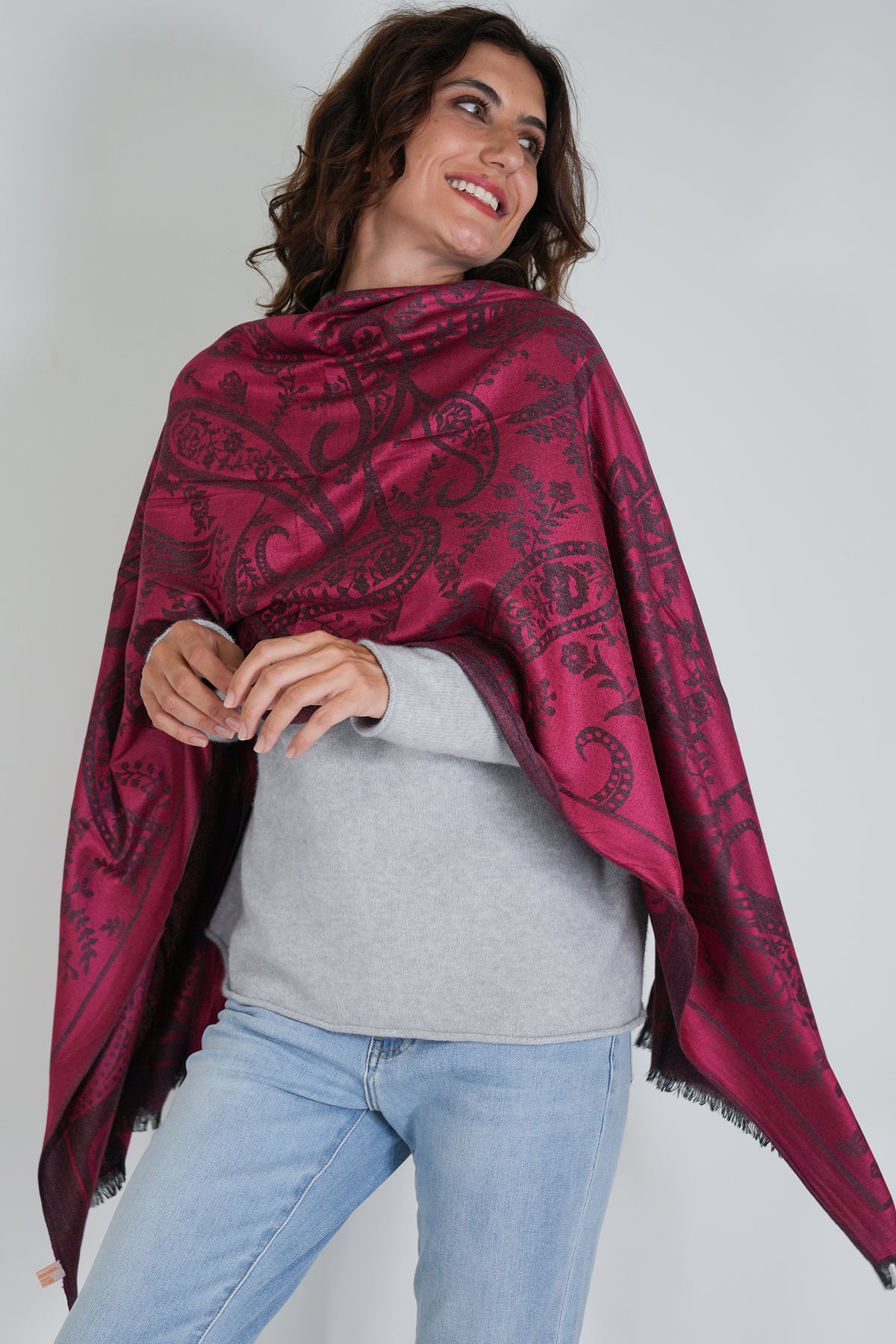Woman wearing a red patterned scarf on a plain background