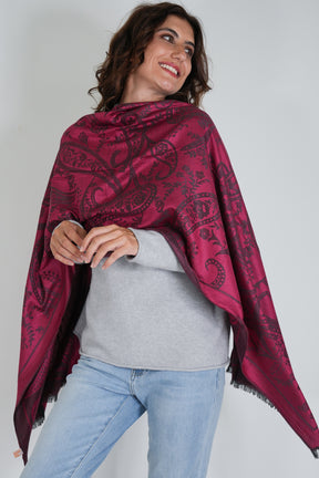 Woman wearing a red patterned scarf on a plain background