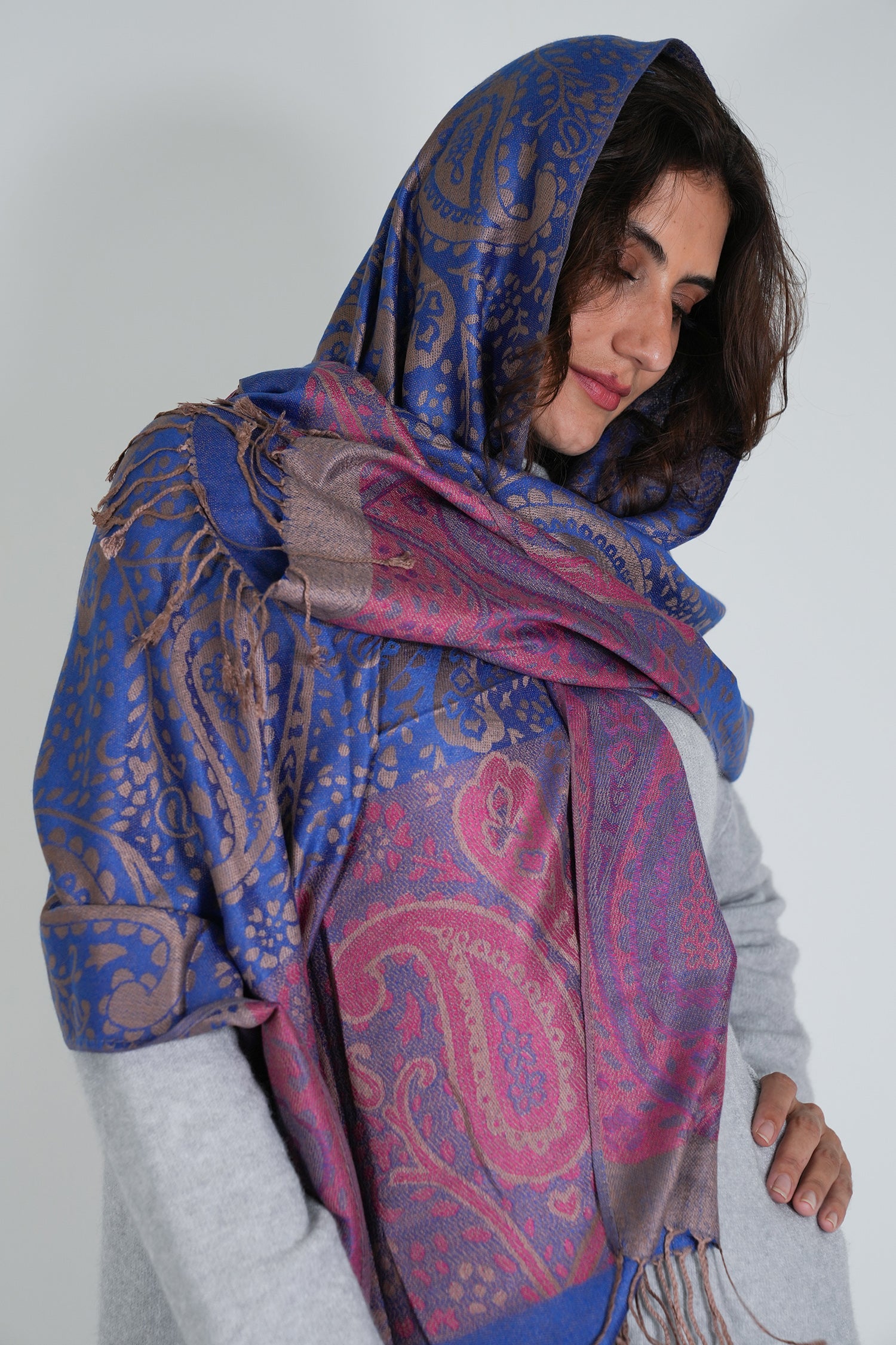 Woman wearing a blue and pink patterned scarf on a white background