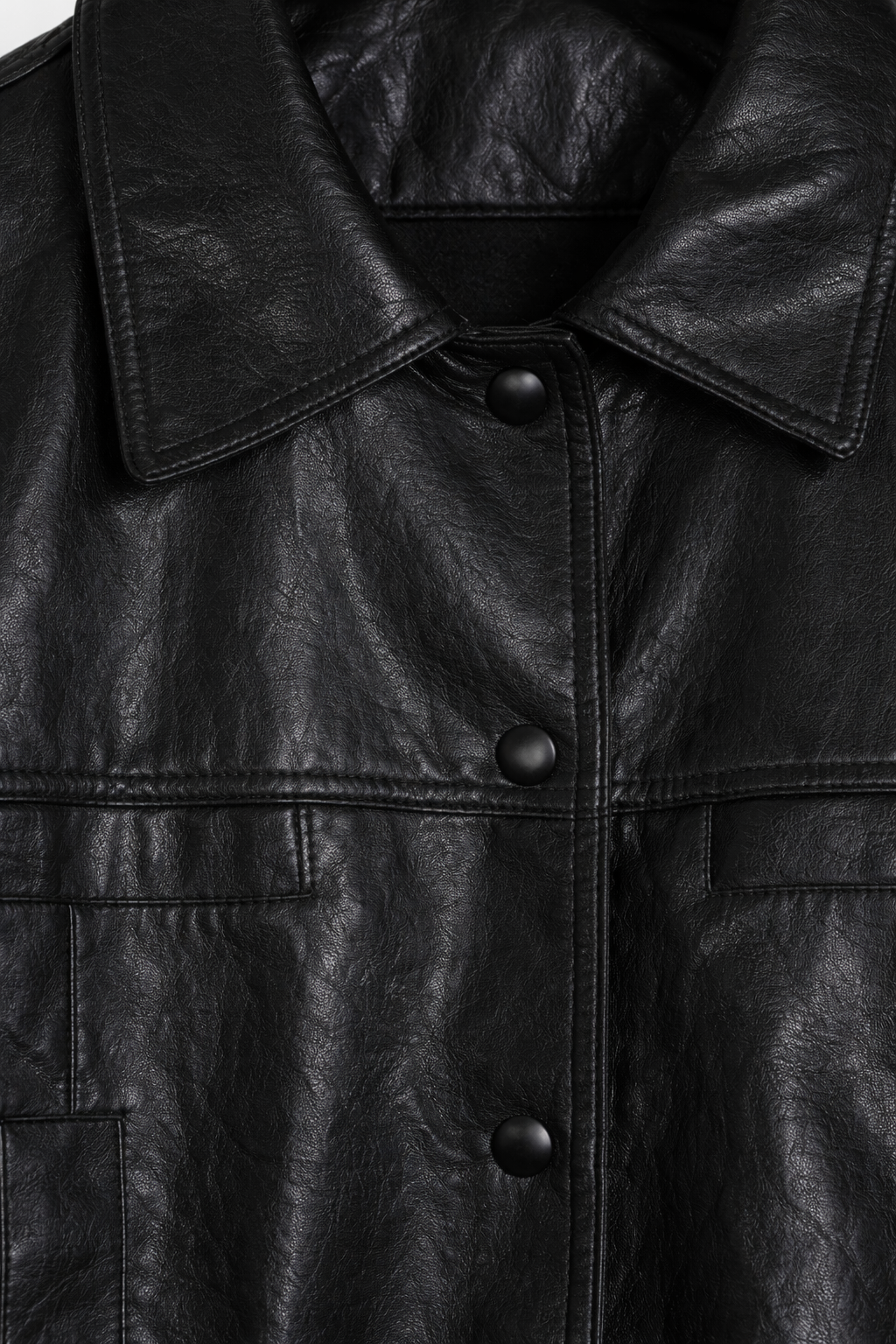 Close-up of a black leather jacket with buttons