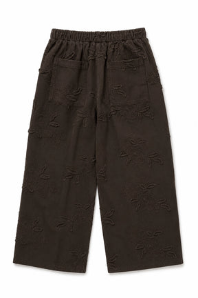 Dark brown cropped pants with an all-over tonal floral jacquard pattern, featuring an elastic waistband and side pockets, shown flat on a white background.
