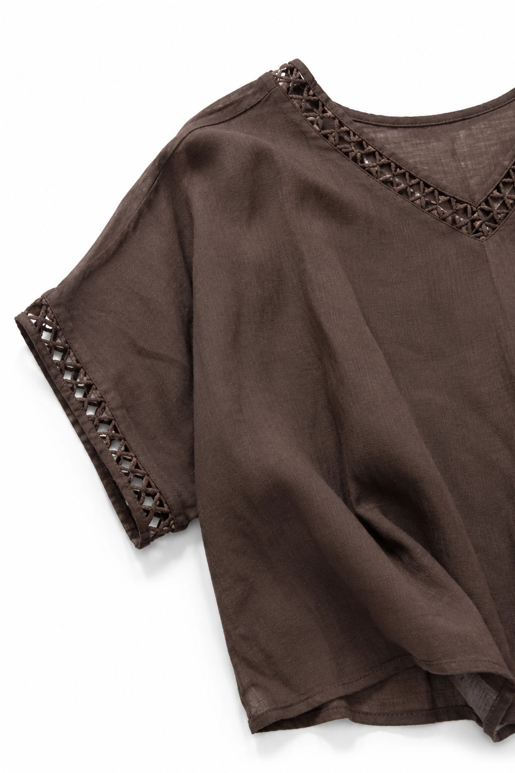 A close-up of a brown short-sleeve top with decorative cutout lace trim along the V-neckline and sleeve cuffs, shown on a white background.