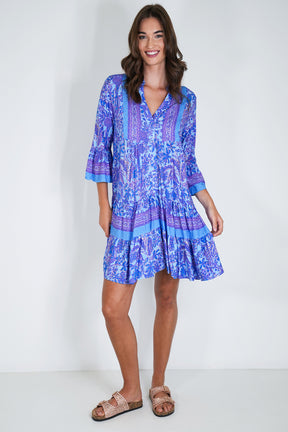 Woman wearing a blue patterned dress on a white background