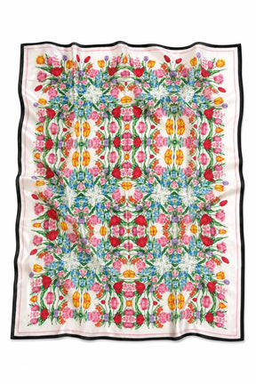 A square scarf with a vibrant, symmetrical floral pattern in pink, red, yellow, green, and blue on a white background, finished with a black border.