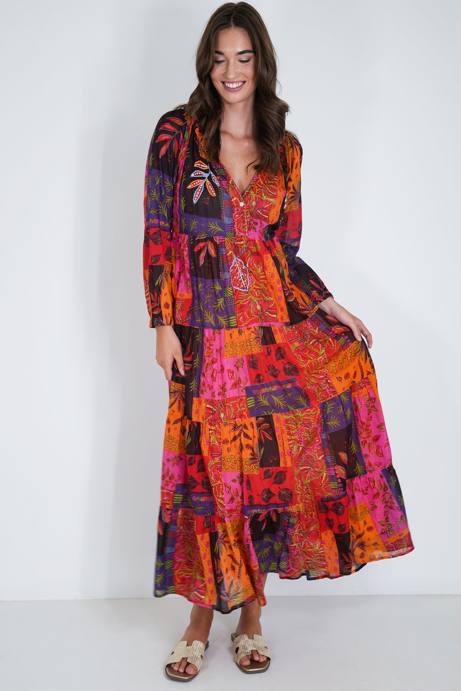 Woman wearing a colorful patchwork dress against a white background