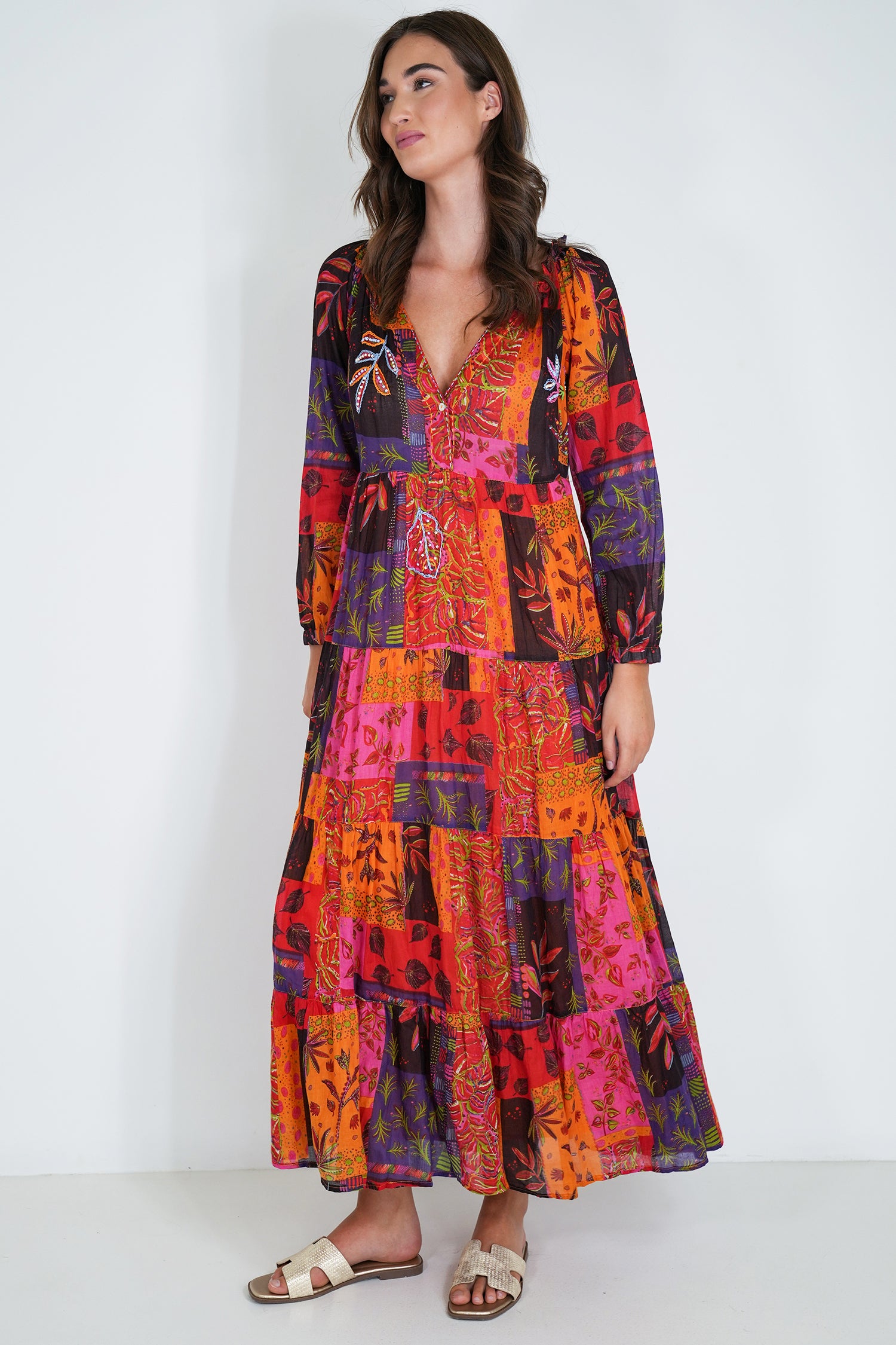 Woman wearing a colorful patchwork dress against a white background