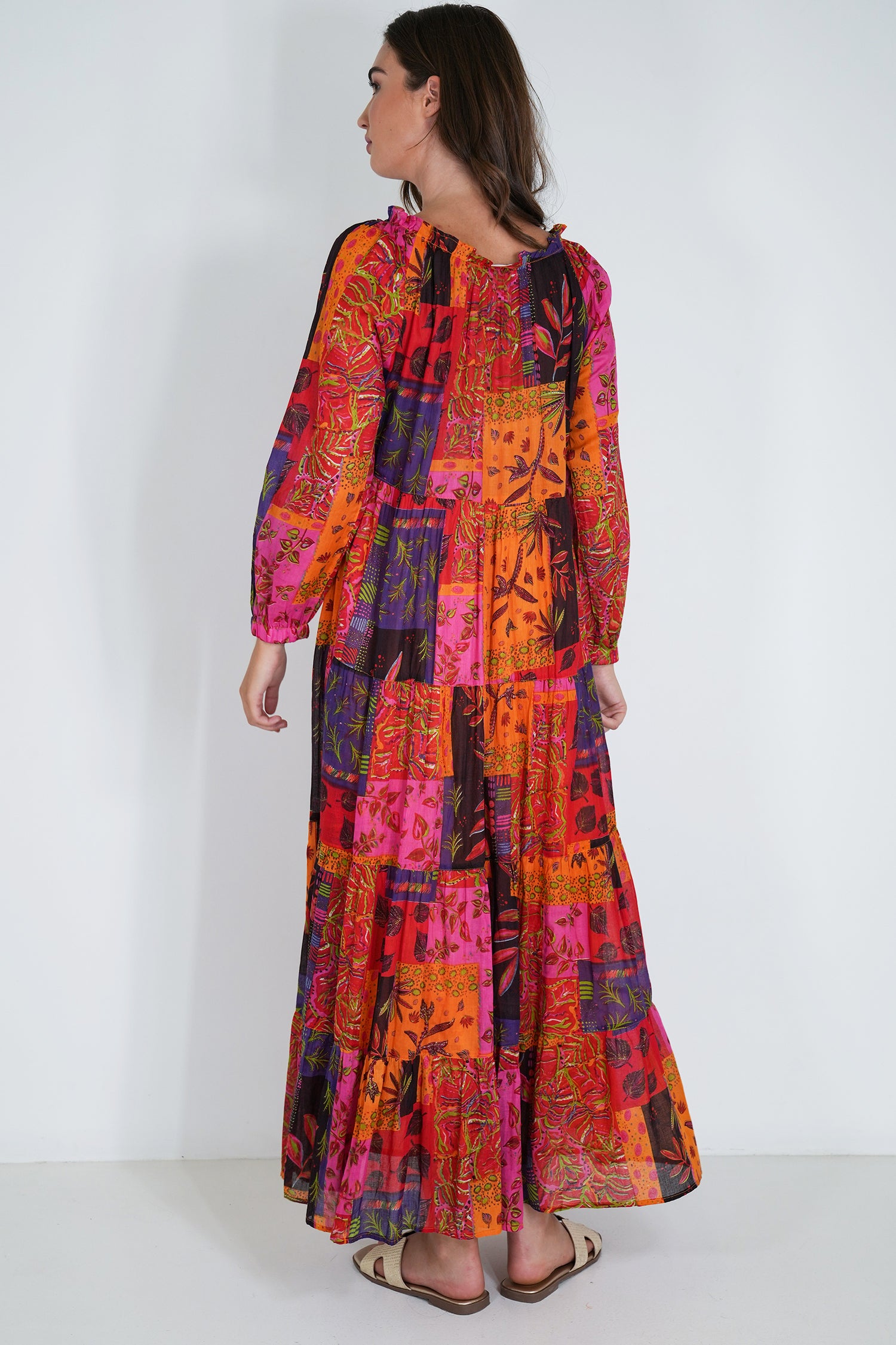 Woman wearing a colorful patterned dress on a white background