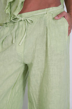Light green pants with a drawstring waist on a plain background