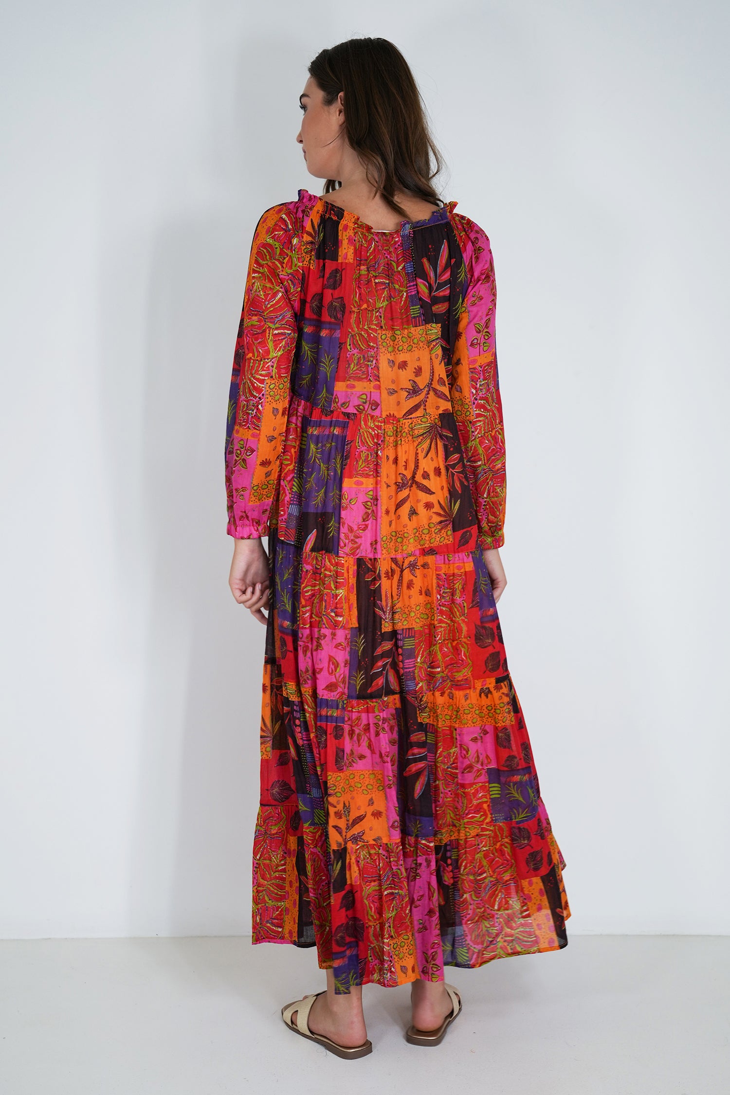 Woman wearing a colorful patterned dress on a white background