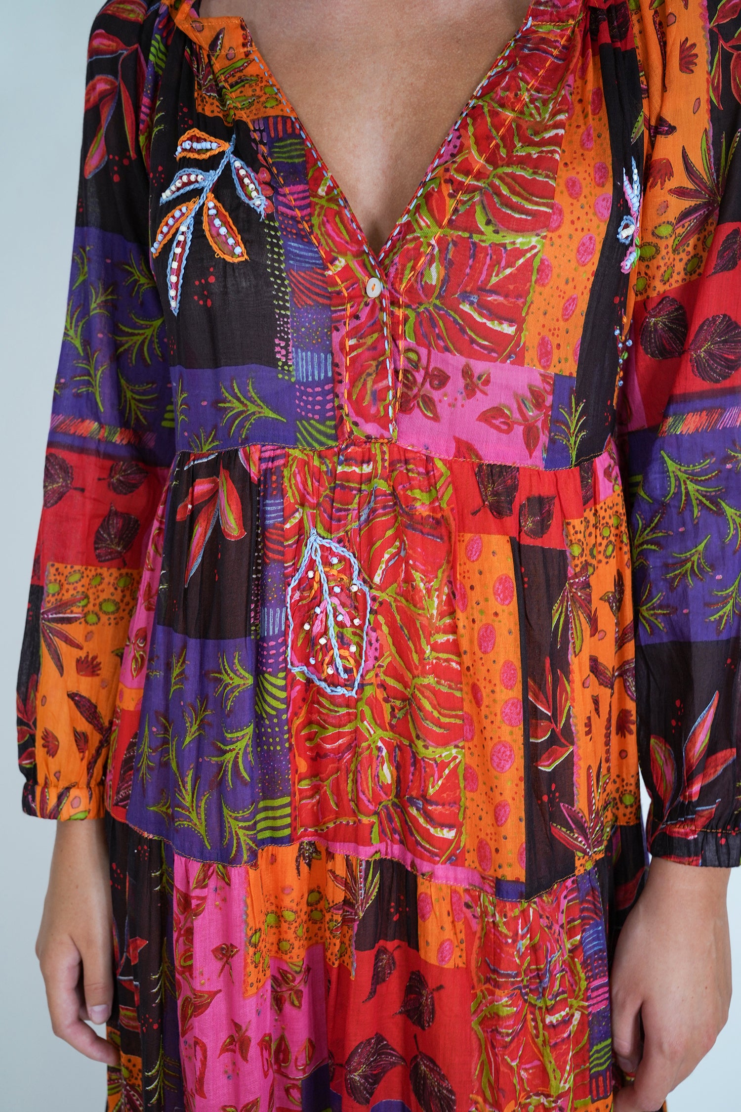 Colorful patterned dress with long sleeves on a plain background