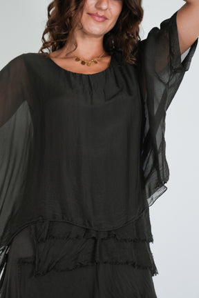 Close-up of the Chocolate Overlay Tier Silk Dress showing sheer silk overlay, gathered neckline, and tiered ruffle waist detail 