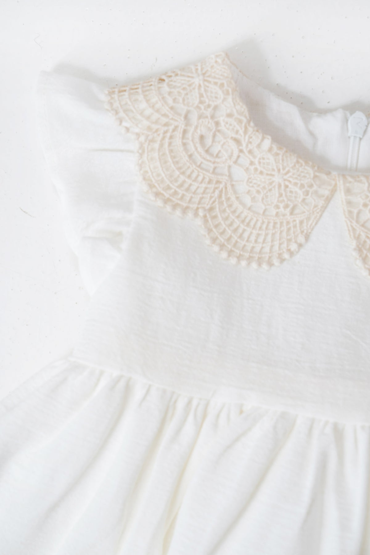 White dress with a lace collar on a white background