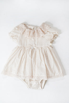 Beige lace baby romper on a white background