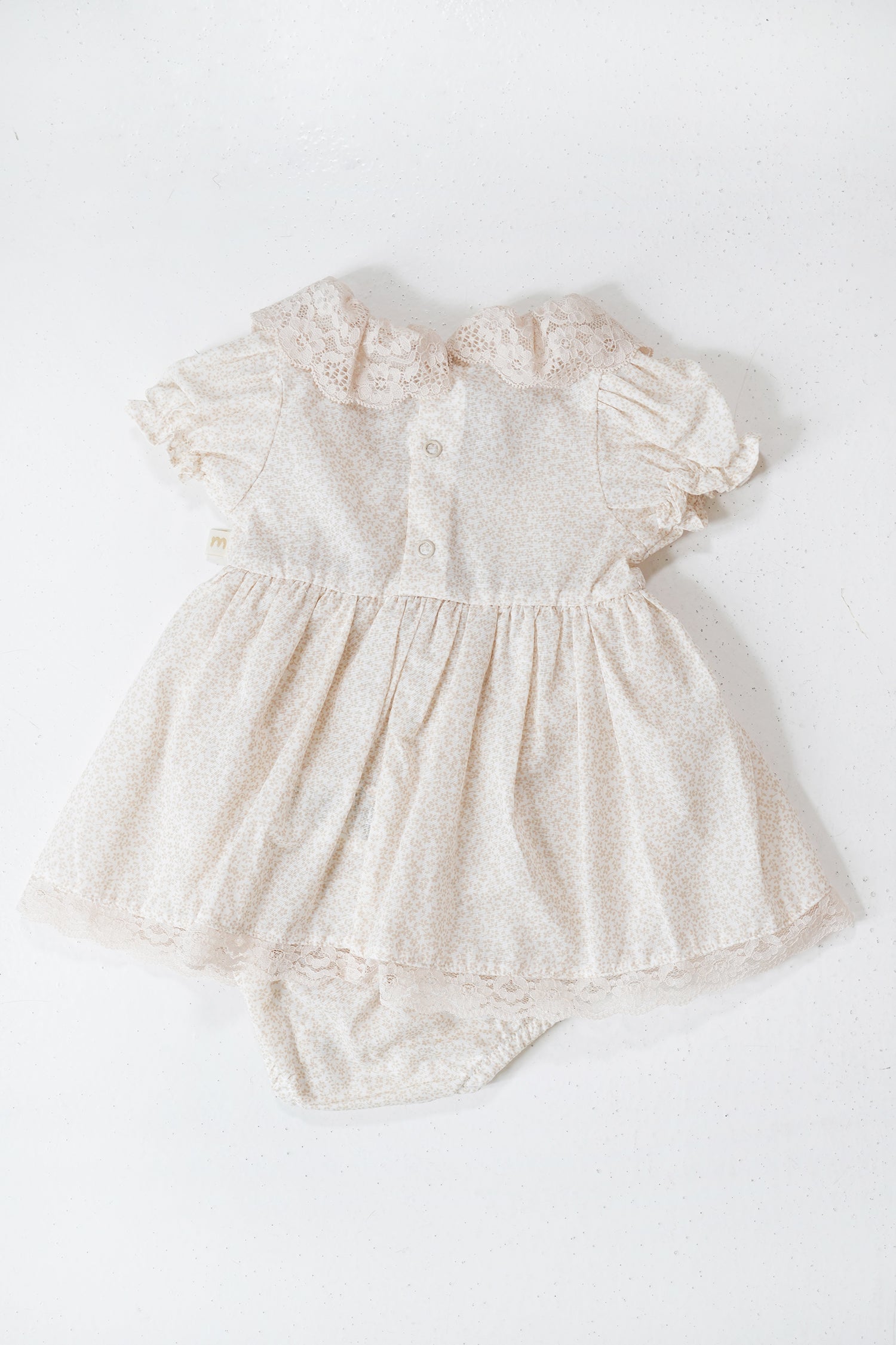 White lace baby romper on a white background