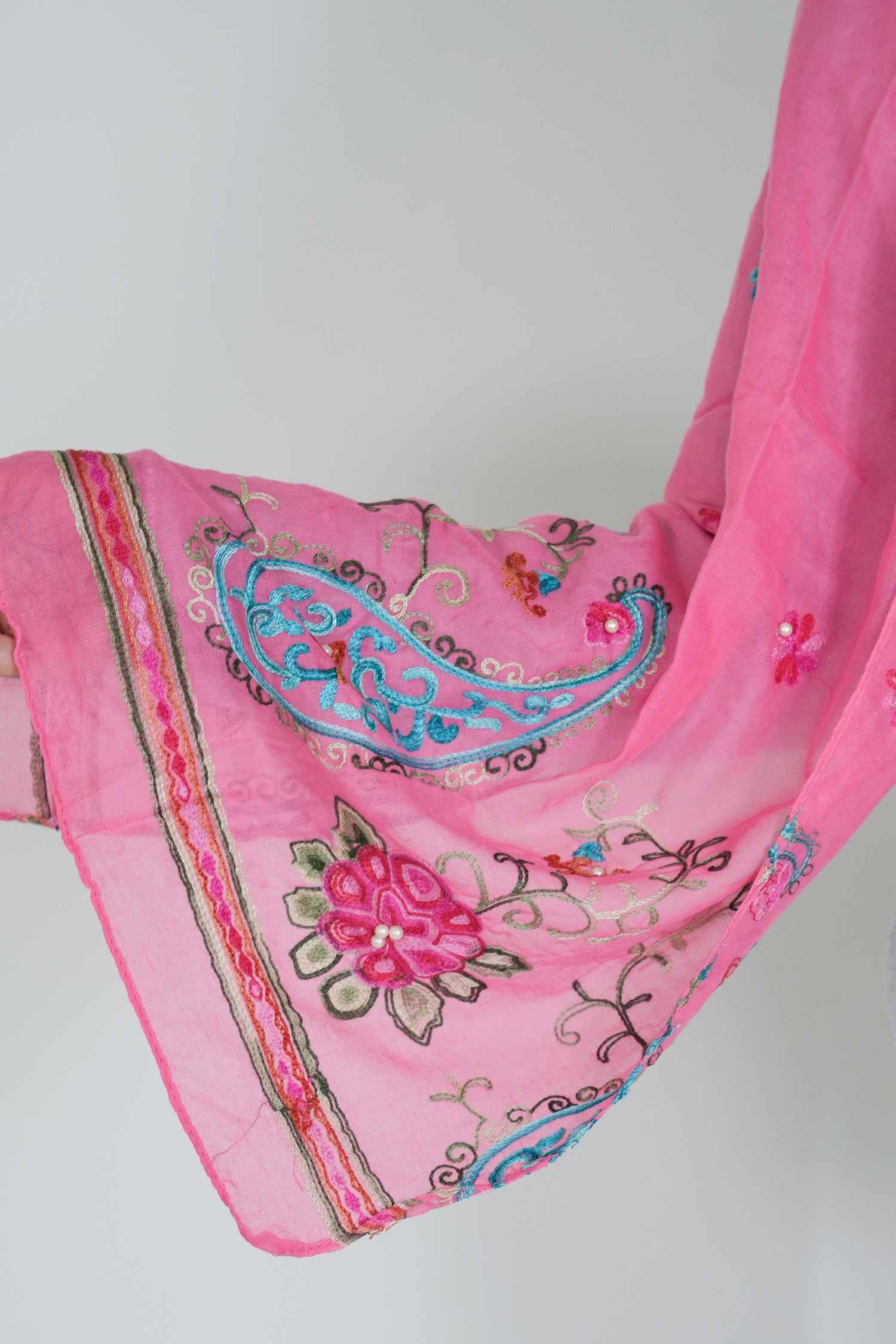 Pink scarf with intricate embroidery on a white background