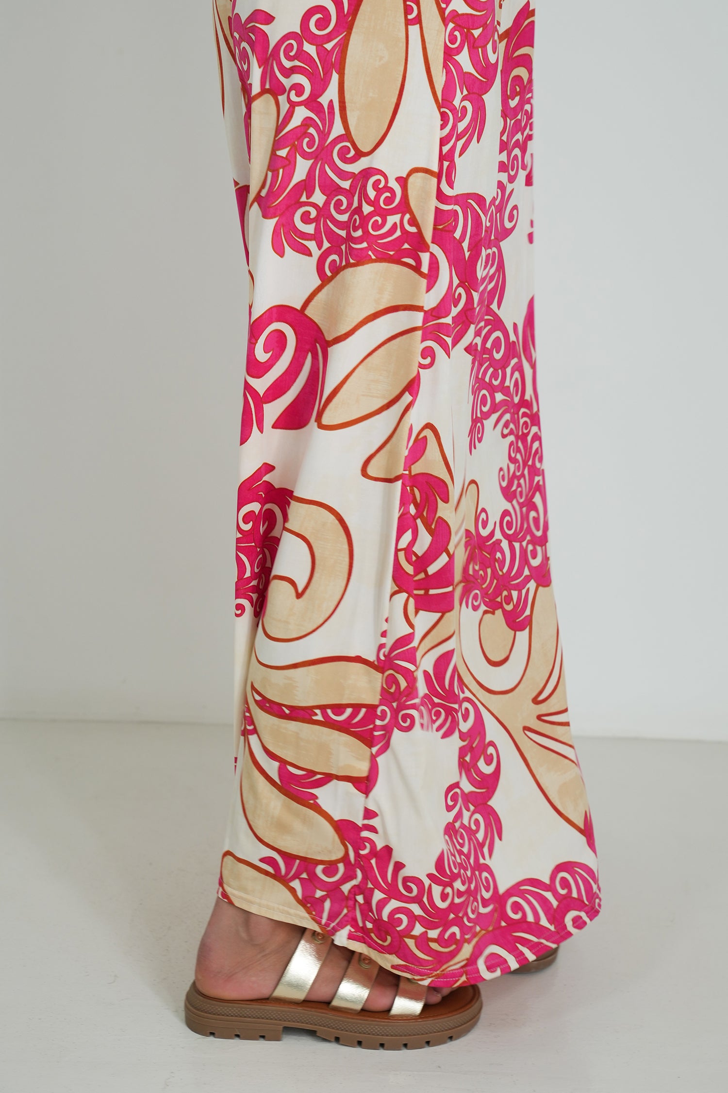 Pink and beige patterned dress on a white background