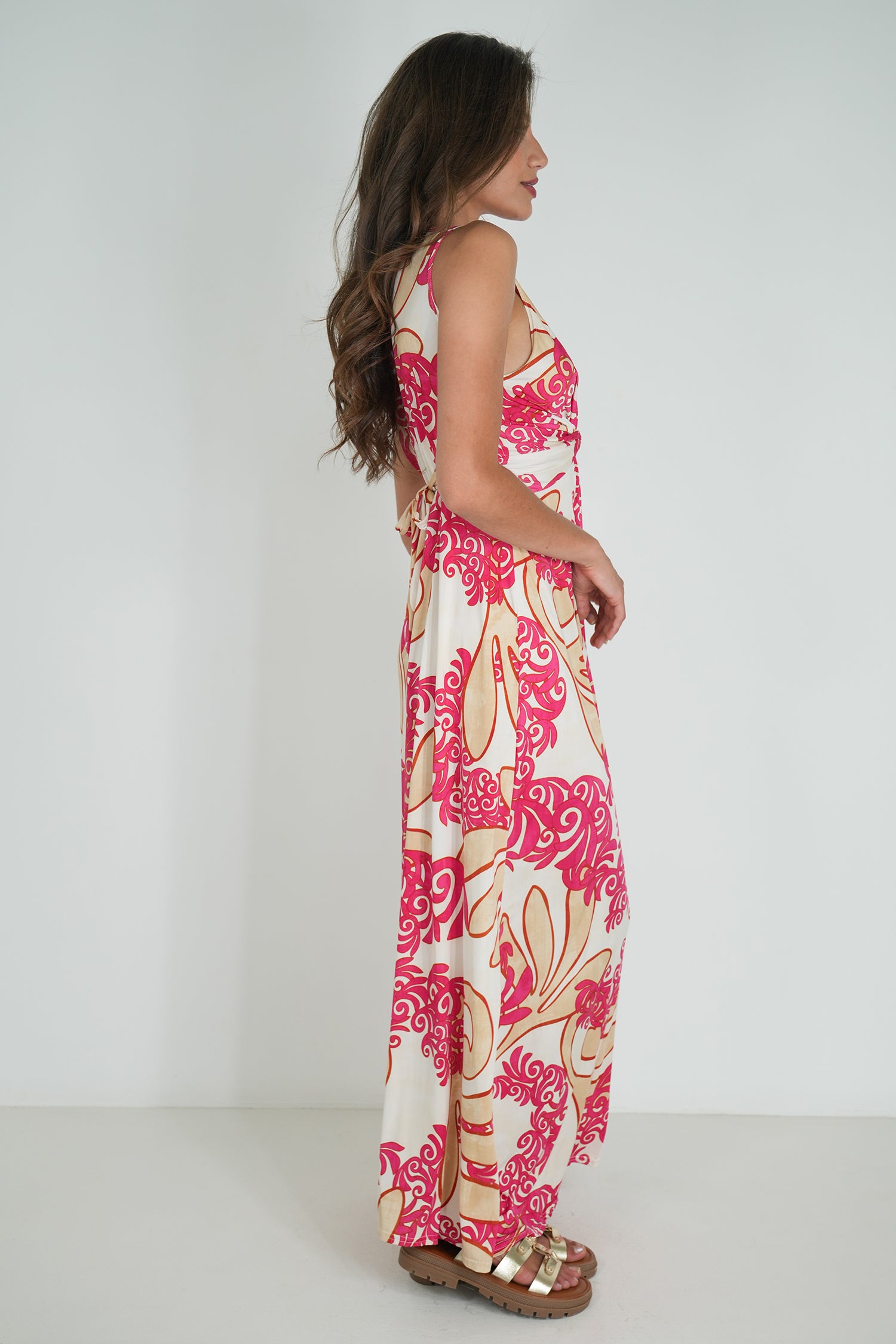 Woman wearing a pink floral dress against a white background