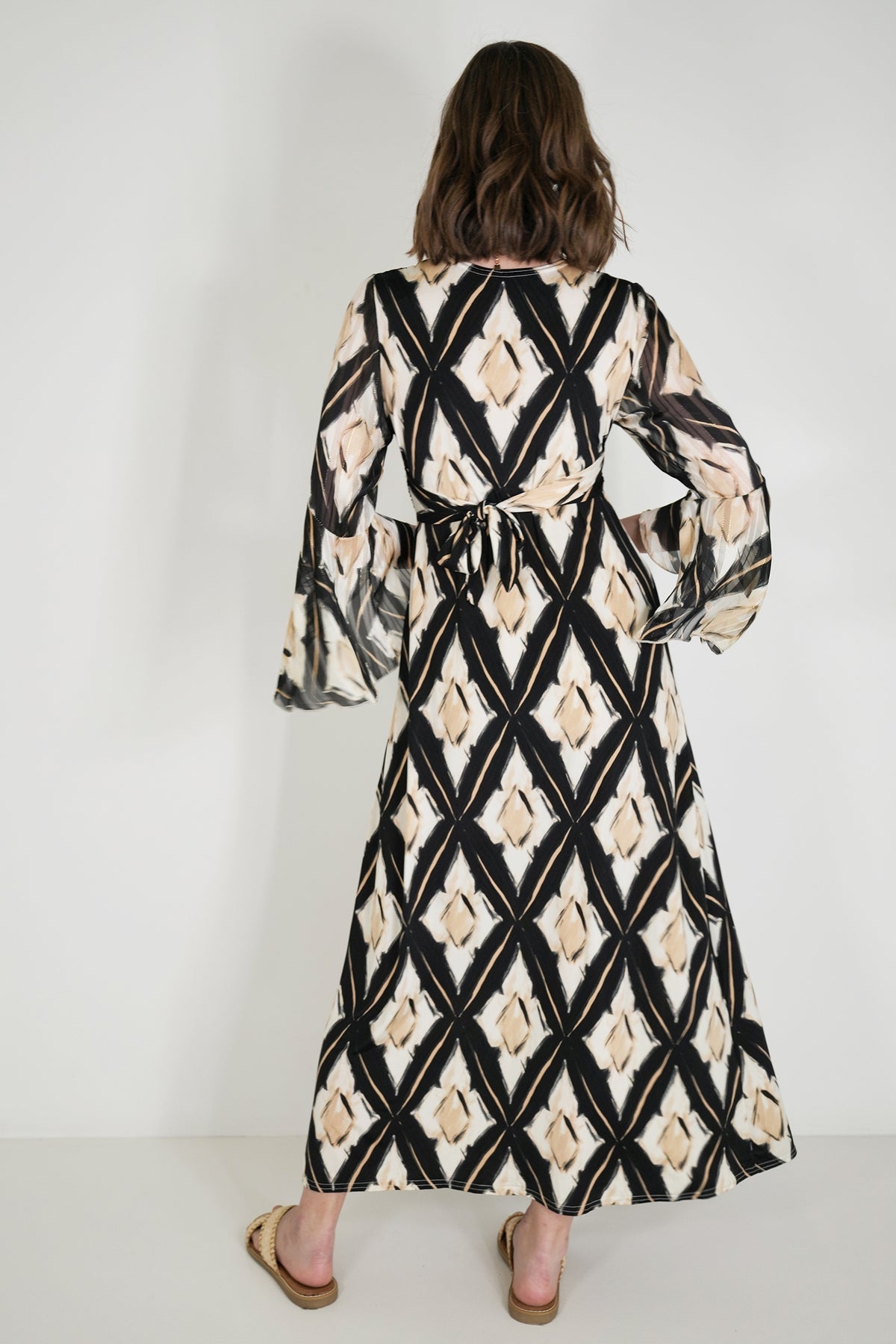 Woman wearing a patterned dress with a white background