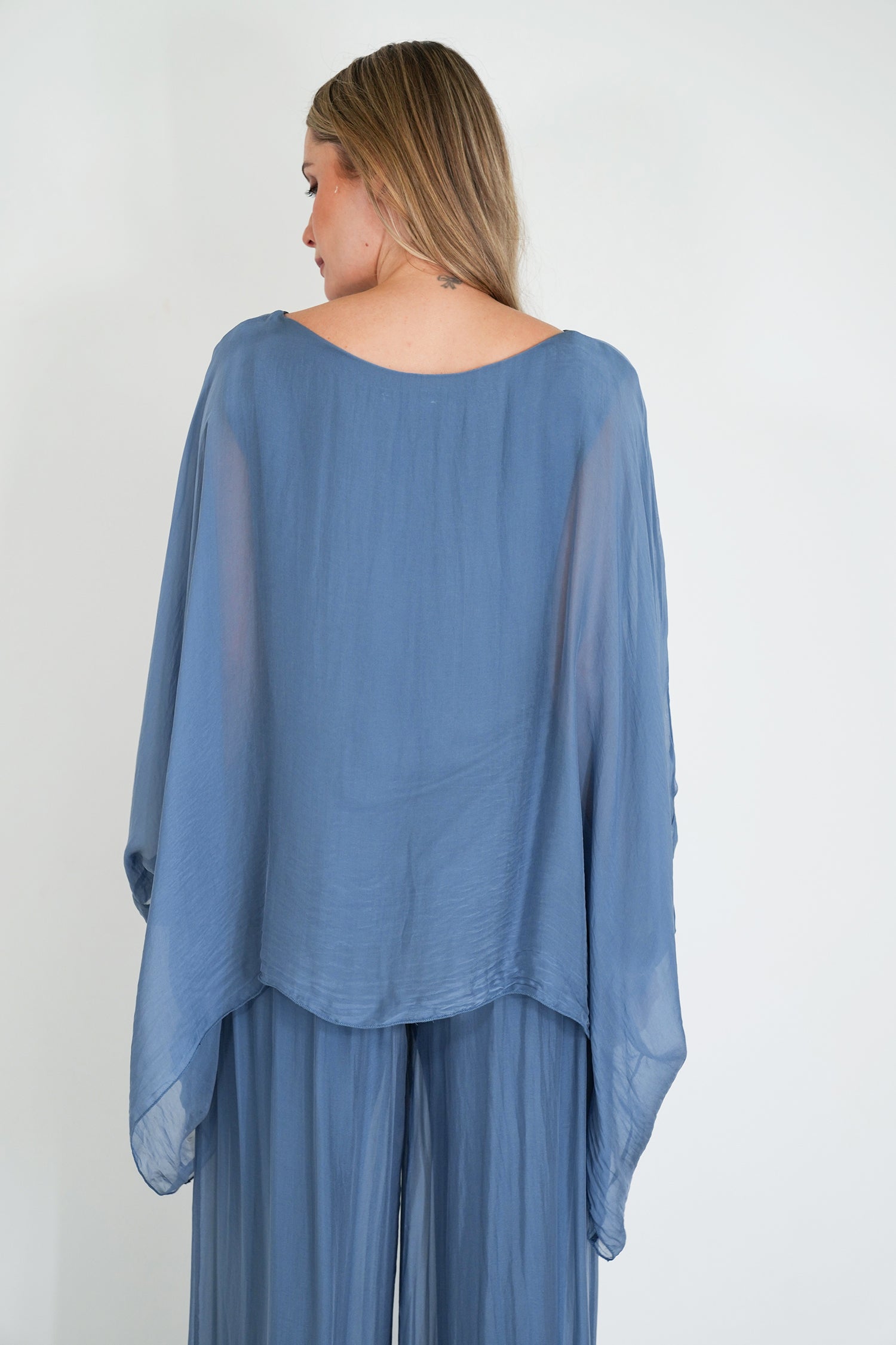 Woman wearing a blue outfit with a plain background