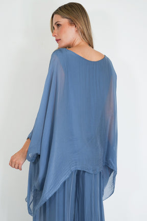 Woman wearing a blue sheer dress against a white background