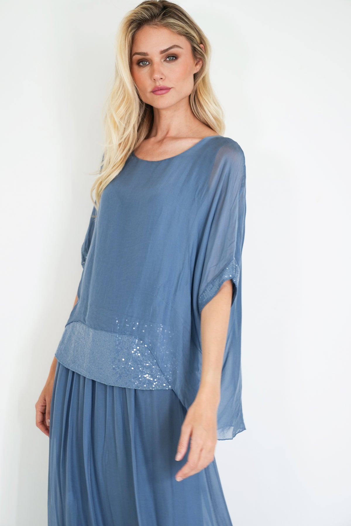 Woman wearing a blue dress with a plain white background