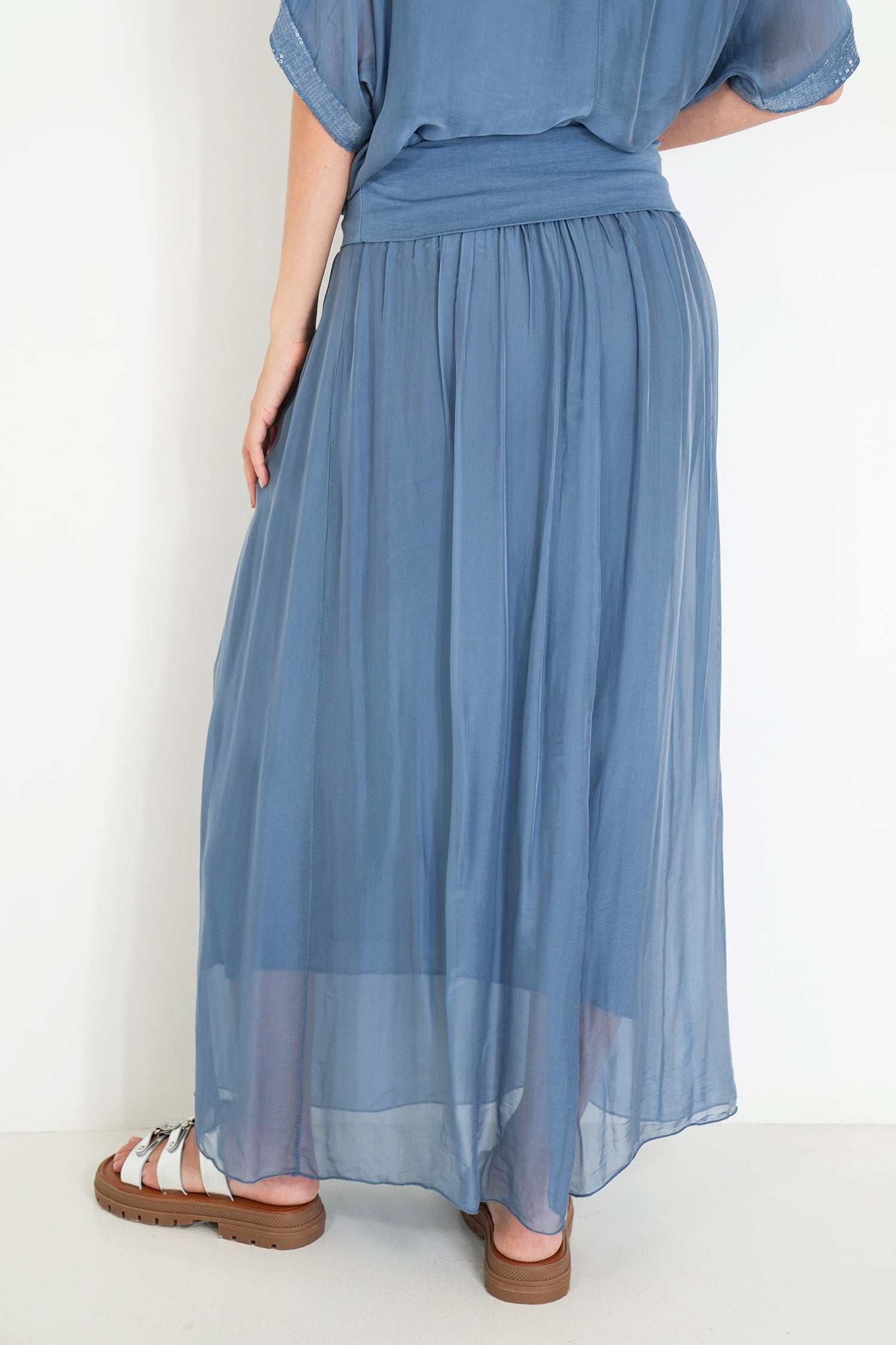 Blue dress worn by a person on a white background