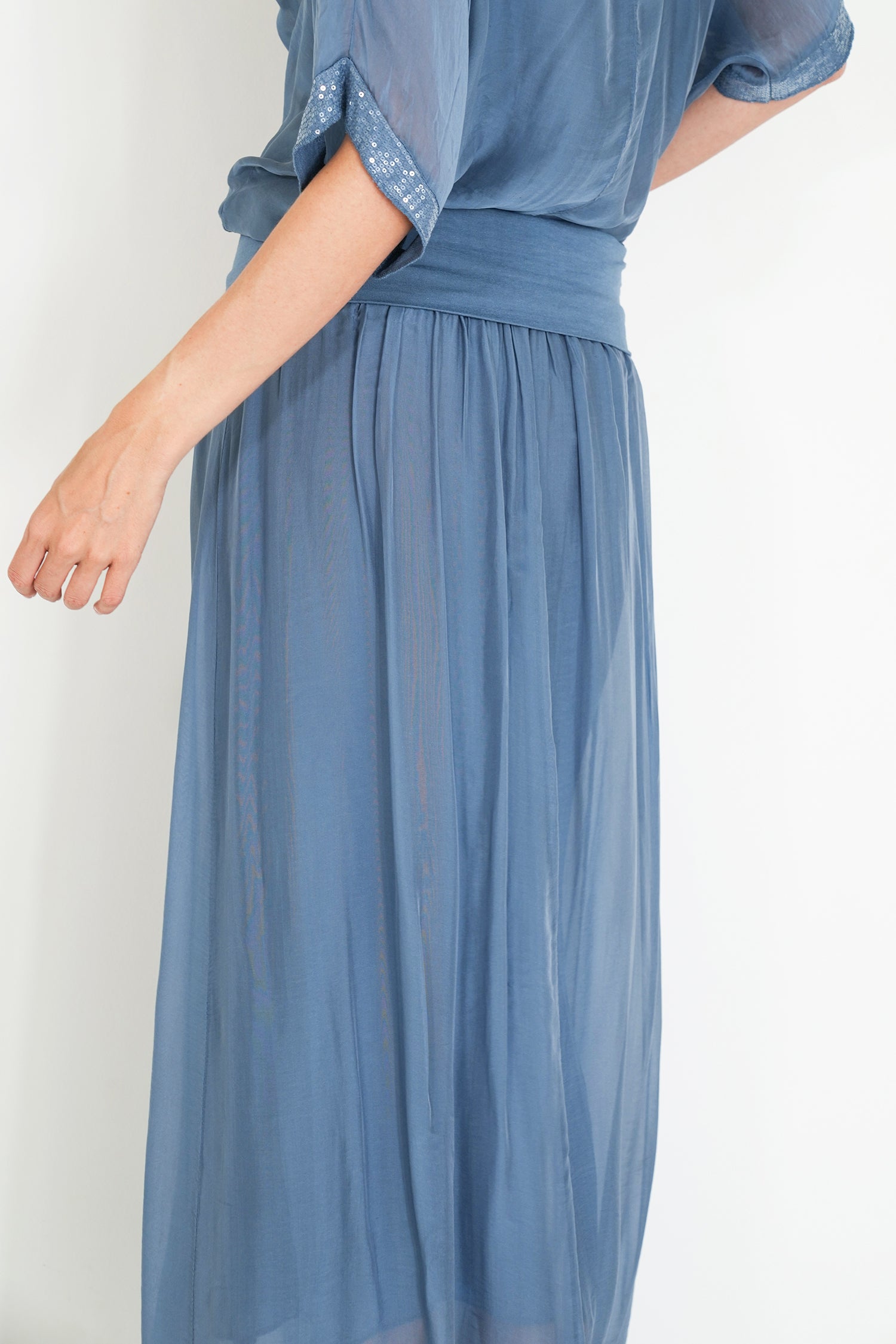 Blue dress with sheer sleeves on a white background