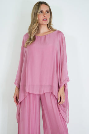 Woman wearing a pink outfit with a plain white background