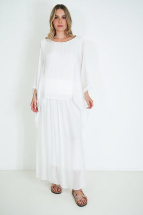 Woman wearing a white dress against a white background